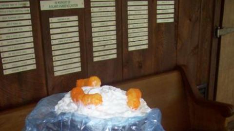 Campers wears a silly hat with shaving cream and Cheetos stuck to it. 