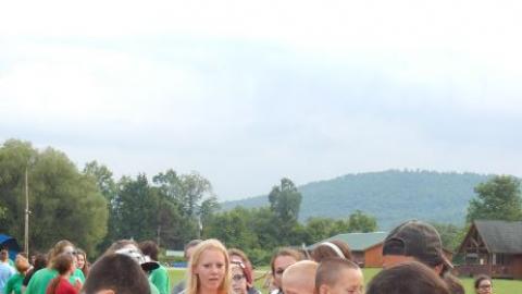 Youth fill their plates for an outdoor meal. 