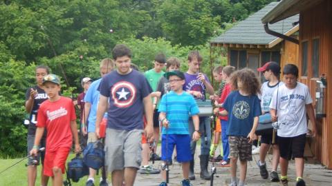 Youth walking with fishing poles in hand. 