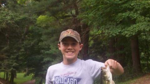 Youth proudly holds up a freshly caught fish. 