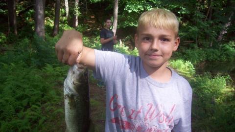 Youth holds up a freshly caught fish. 