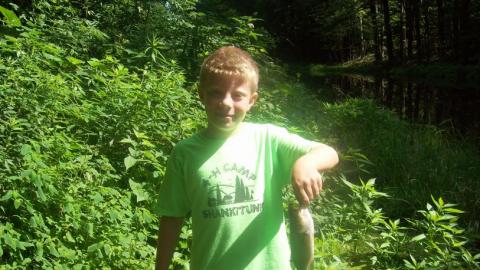 Youth holds up a freshly caught fish. 