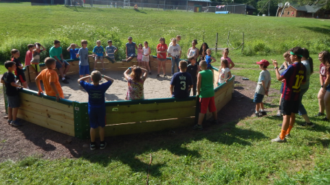 Large group of youth in and around the gaga pit.