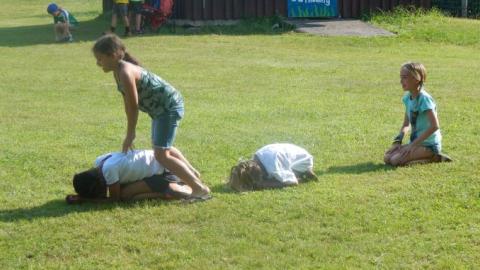 Youth playing a game of leap frog. 