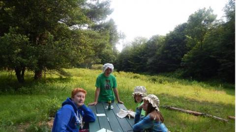 Youth dress in colonial hats during a camp living history class. 