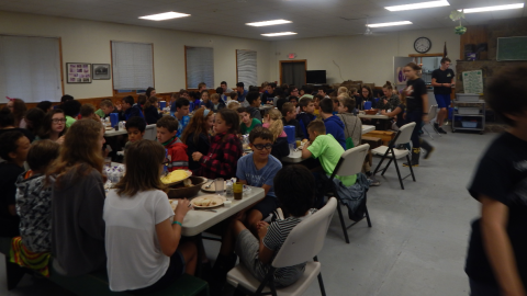 Campers and counselors seated together for a family style meal.