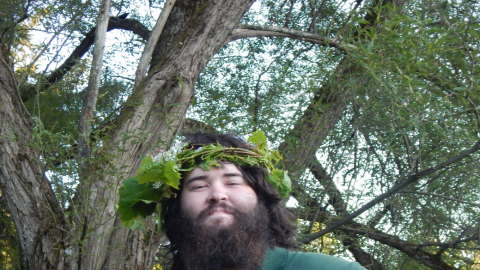 Staff looking proudly into camera wearing a crown made of vines.