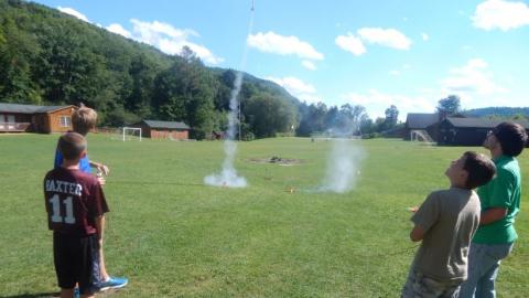 Youth watching model rockets launch. 