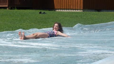 Youth smiles while going down a giant slip and slide. 