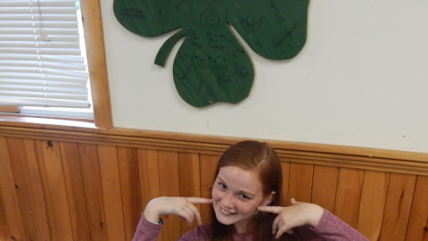 Camper pointing to cheeks and smiling.