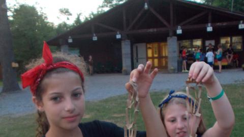 two campers doing arts and crafts with brown paper