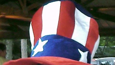 camper wears a patriotic hat and make-up and smiles for the camera 