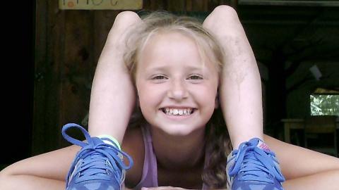 camper doing optical illusion where it looks like their feet are bent back over their head.