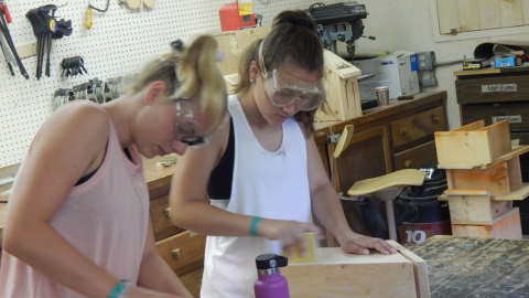 Two youth sand bird houses in the wood shop.