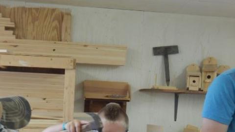 Camper works on a wood project in the camp wood shop. 